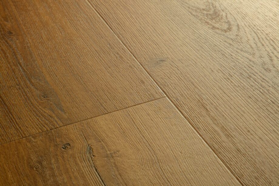 vinyylilankku-quick-step-bloom-botanic-caramel-oak Vinyylilankku Quick Step Bloom Botanic Caramel Oak, lämmin karamellinruskea tammen sävy ja lankkudesign.