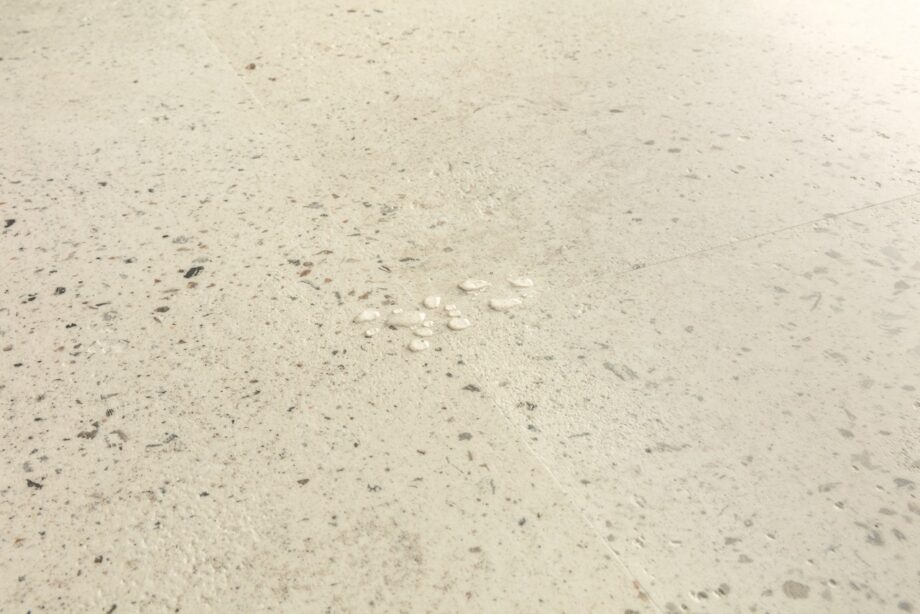 vinyylilaatta-quick-step-illume-pebble-concrete Vinyylilaatta Quick-Step Illume Pebble Concrete asennettuna modernin kodin lattialle – vaalean greige/betoninsävy ja pehmeä, hienovaraisesti elävöity betonikuviointi kivimäisellä tekstuurilla.