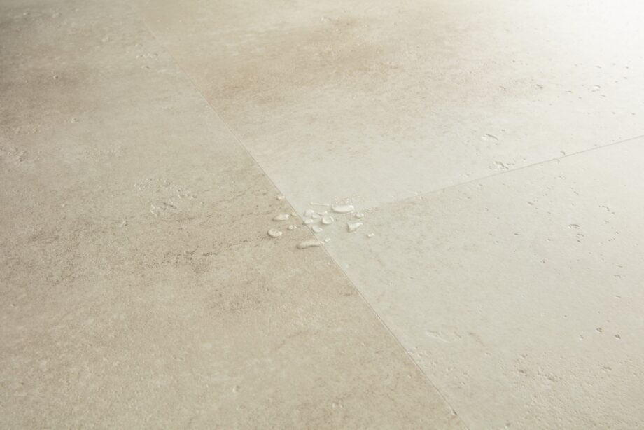 vinyylilaatta-quick-step-illume-sandstone-concrete Vinyylilaatta Quick-Step Illume Sandstone Concrete asennettuna modernin kodin lattialle – lämmin hiekkabeige/greige sävy ja luonnollisen pehmeä betonidesign, jossa on hienovarainen kivimäinen tekstuuri.