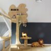 Klickvinyl Quick Step Bloom Cotton Oak Deep Natural im Kinderzimmer verlegt, Kinderbett mit Baldachin, wandmontiertes Holzregal in Baumform, weiches Löwen-Kuscheltier auf dem Boden.