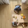 LVT parkett Quick Step Bloom Brushed Oak Beige paigaldatud söögitoa põrandale, söögilaud ja toolid, pere einestamas laua taga.