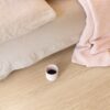 lvt-porandakate-quick-step-bloom-pure-oak-blush LVT põrandakate Quick-Step Bloom Pure Oak Blush paigaldatud magamistoa põrandale. voodi ja kohvitass põrandal
