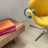 LVT põrandakate Quick-Step Blos Canyon tamm beige paigaldatud kodukontori põrandale. Kollane kontoritool millel sinised kõrvaklapid. Kummut millel on raamatud.