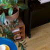 vinyl-floor-quick-step-bloom-cotton-oak-natural Vinyl floor Quick-Step Bloom Cotton Oak Natural installed in living floor, piano, blue table and flowers.