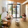 vinyl-floors-quick-step-bloom-brushed-oak-honey Vinyl floors Quick-Step Bloom Broshed Oak Honey installed on a hallway floor. Family with dog, sofa, stool.
