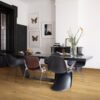 Виниловый ламинат Quick Step Bloom Cotton Oak Deep Natural уложен на полу в столовой, современный обеденный стол с каменной столешницей, стулья вокруг стола, на столе цветы.