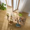 виниловый-паркет-quick-step-bloom-brushed-oak-honey Виниловый паркет Quick Step Bloom Brushed Oak Honey уложен на полу на кухне, обеденный стол со стульями и открытая дверь на террасу.