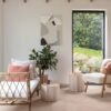 LVT põrandakate Quick-Step Illume Soft blush paigaldatud elutoa põrandale. Lamamistool, tugitool roheline taim ja teelauad toolide kõrval.