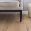 tammiparketti-bauwerk-boen-casapark-tammi-46-vivo-harjattu-avorio-vaalea-oljyvahattu-138mm Tammiparketti Bauwerk Boen Casapark tammi 46 Vivo Avorio (138 mm), harjattu ja öljyvahattu, asennettuna käytävän lattialle – lähikuva lattiapinnasta, taustalla näkyy osittain sohva. Vaalea Avorio-sävy ja rustiikkinen sorteerus korostavat tammen eläväistä kuviointia.