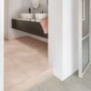 Vinyl tile flooring Quick-Step Illume Soft blush installed on a bathroom floor. Bathroom furniture.